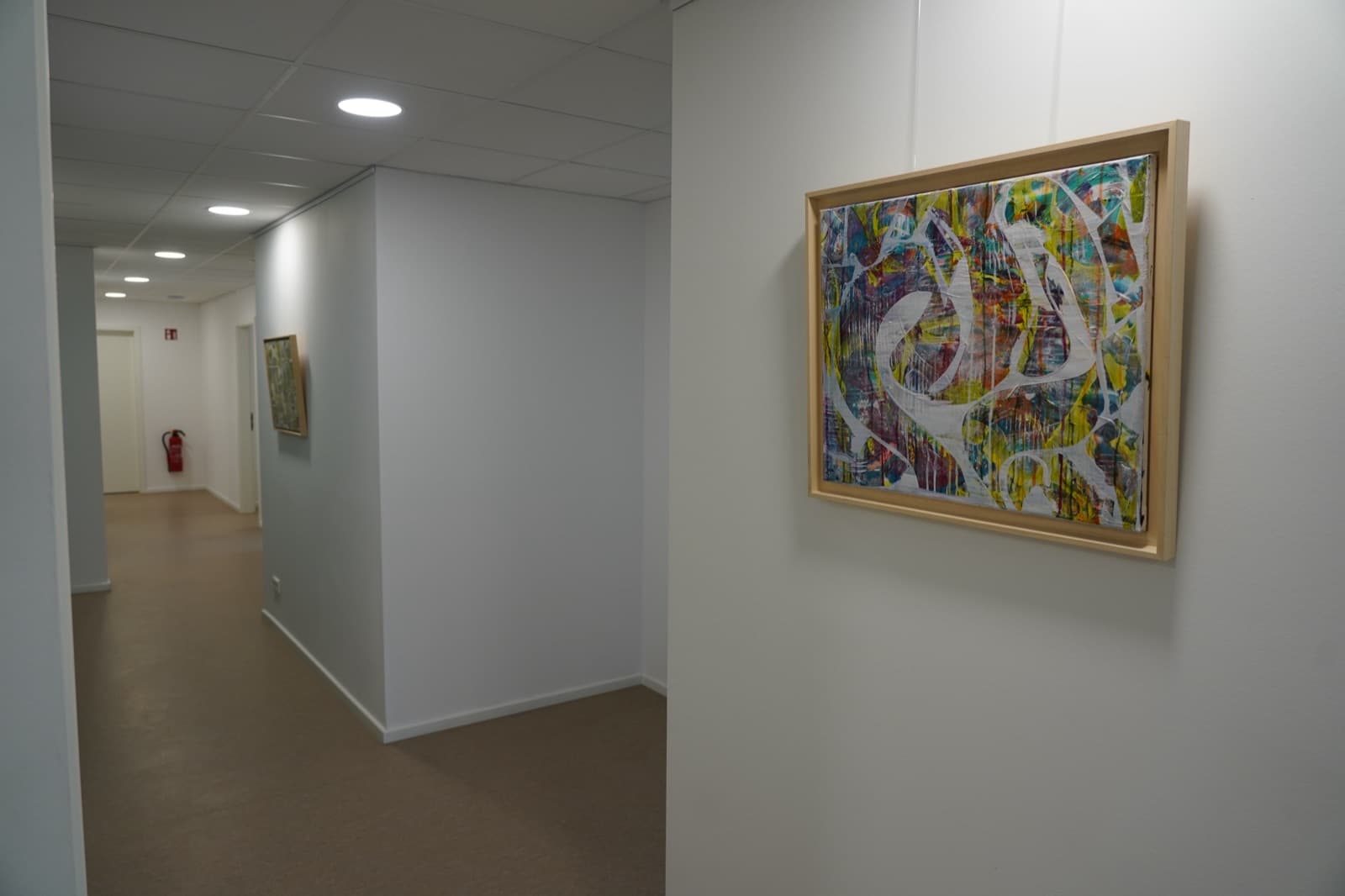 Praxisflur mit Türen zu den Untersuchungsräumen und Kunst