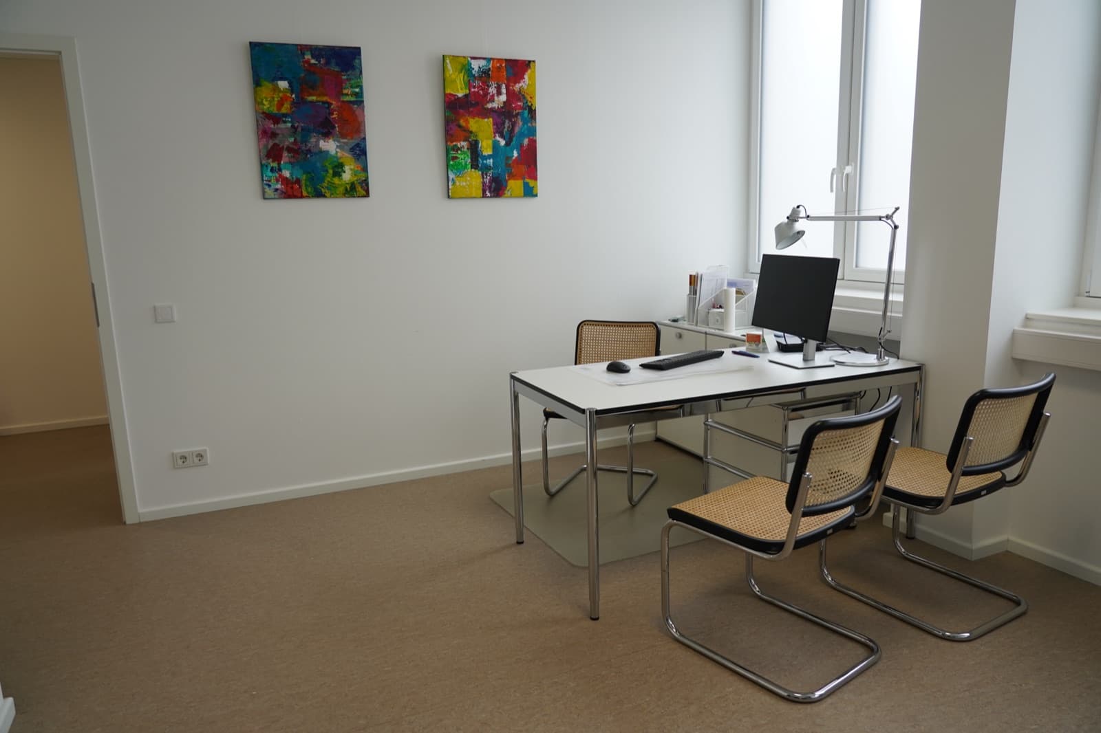 Weiteres Sprechzimmer mit bunter Kunst an der Wand