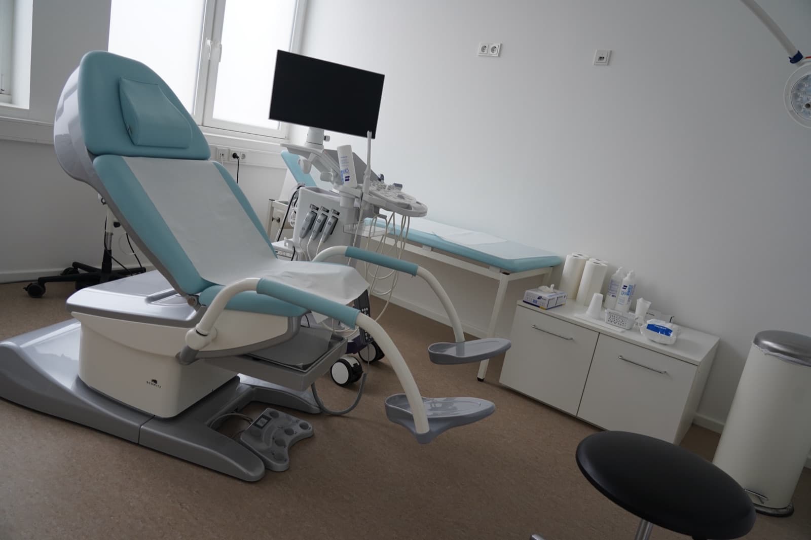 Moderner Untersuchungsstuhl mit Ultraschallgerät und Bildschirm