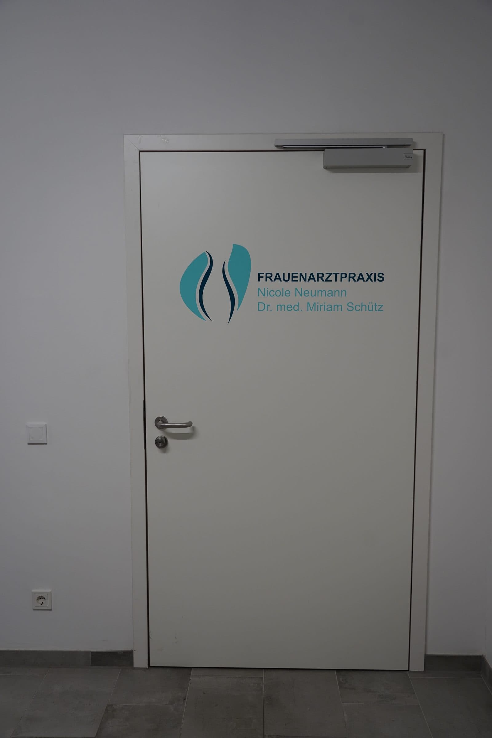 Eingangstür der Frauenarztpraxis mit Logo